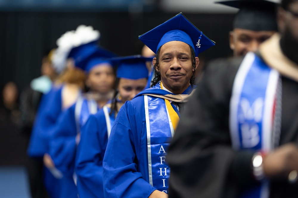 Kristopher Fletcher standing in line at graduation.