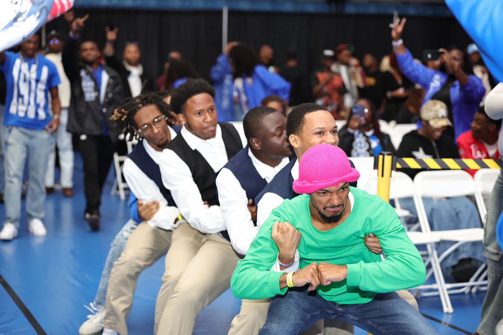 New members of an FSU fraternity stepping in formation during an NPHC probate as a crowd in Bronco blue cheers behind them
