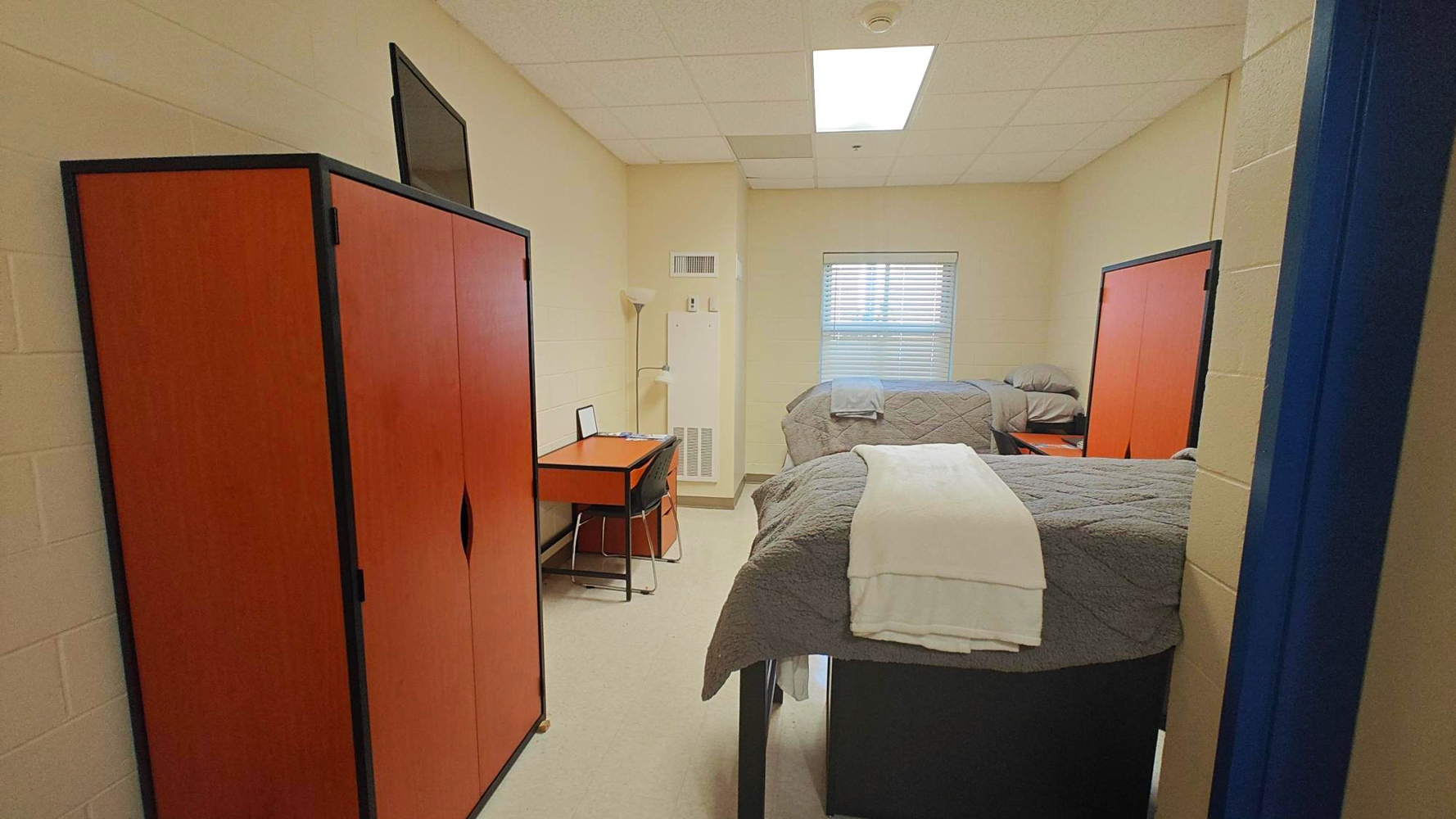 The same bedroom, a red desk in view.