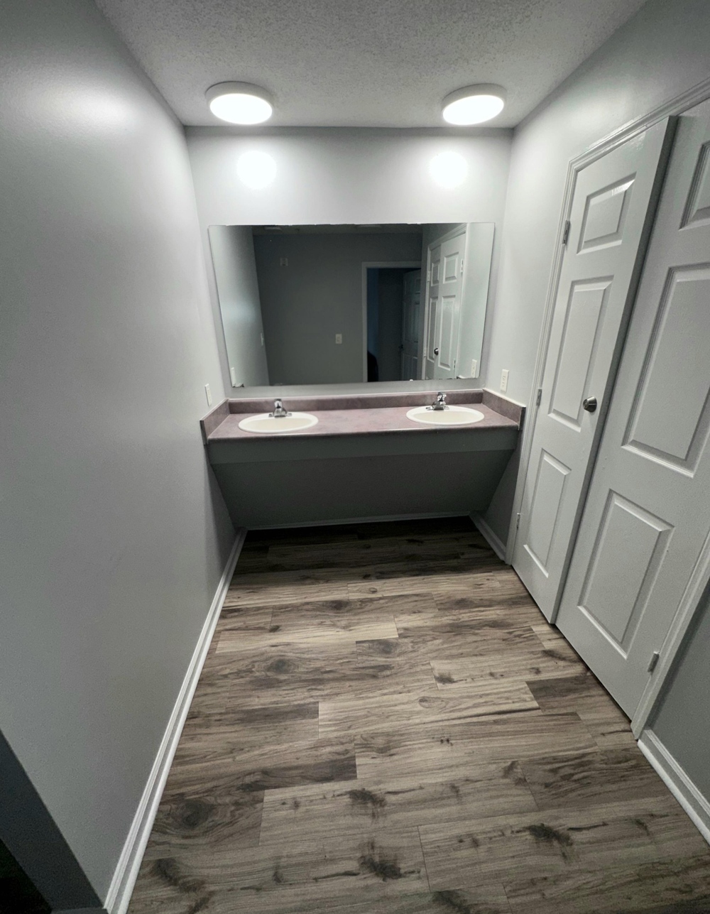 A softly lit bathroom, with double sinks.