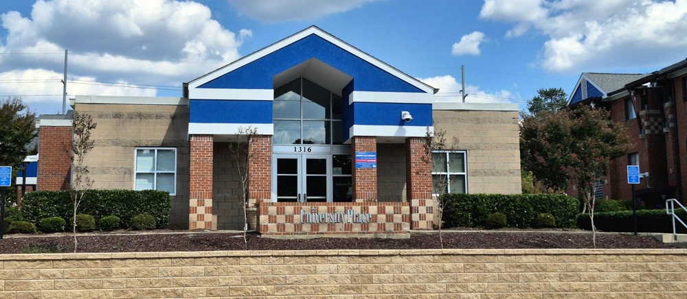 The front of the main building for the apartments. A sign saying 