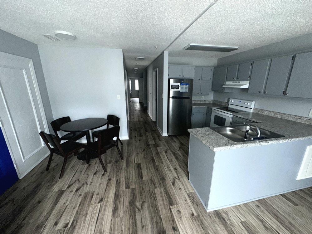 A kitchen complete with stove, fridge and grannit countertops.