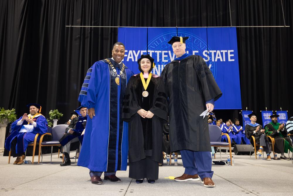The Chancellor standing with two faculty members.