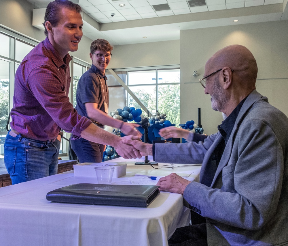 Ethan Kessler and Tyler Renken, both students at Campbell University, shake hands with the judges