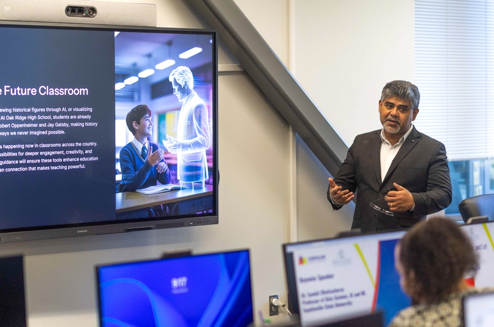 An instructor lecturing to participants in front of computer screens.