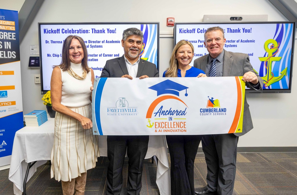 Four instructors standing behind a banner which reads: Anchored IN EXCELLENCE & AI INNOVATION