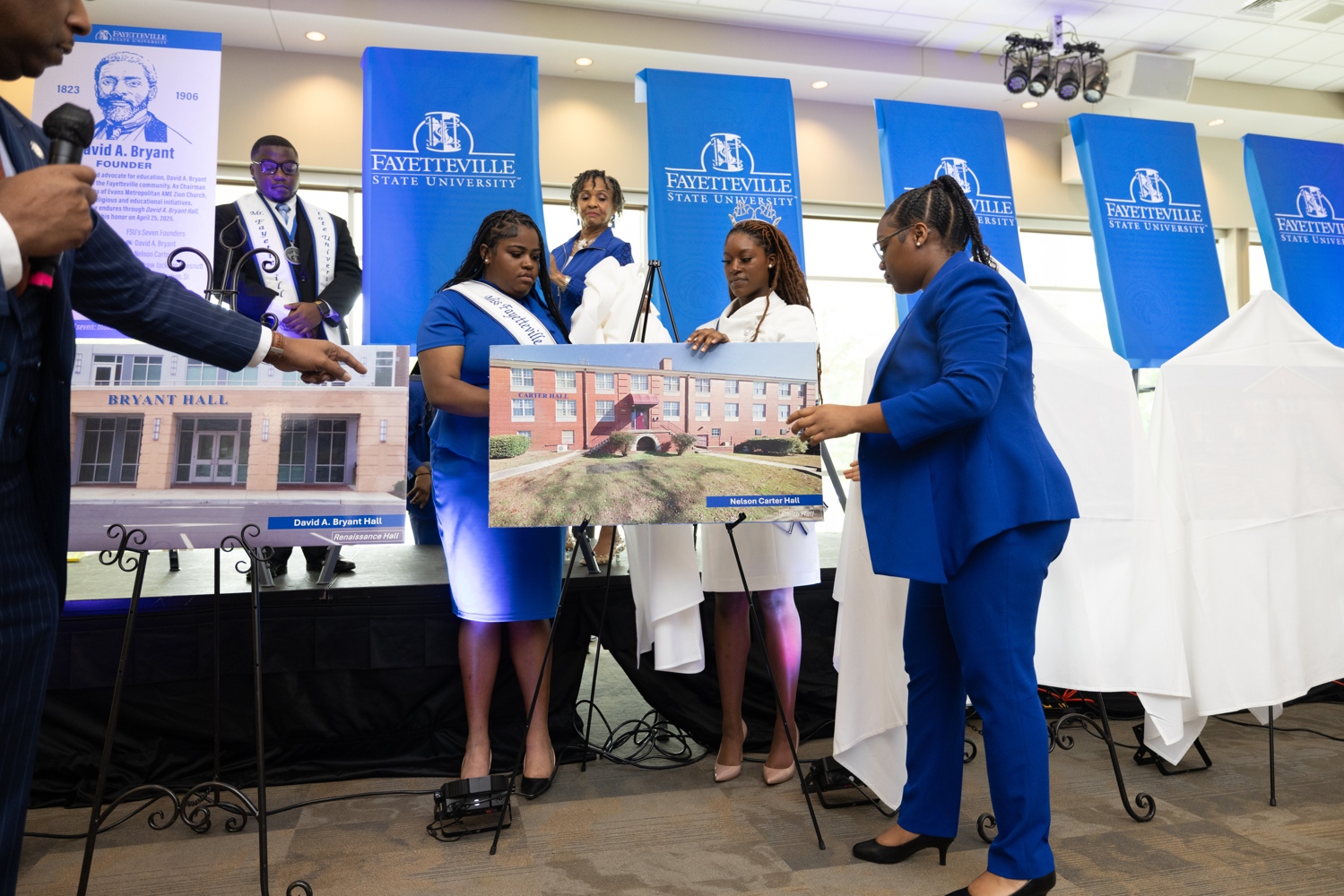 Students holding up images of the newly named residence halls.