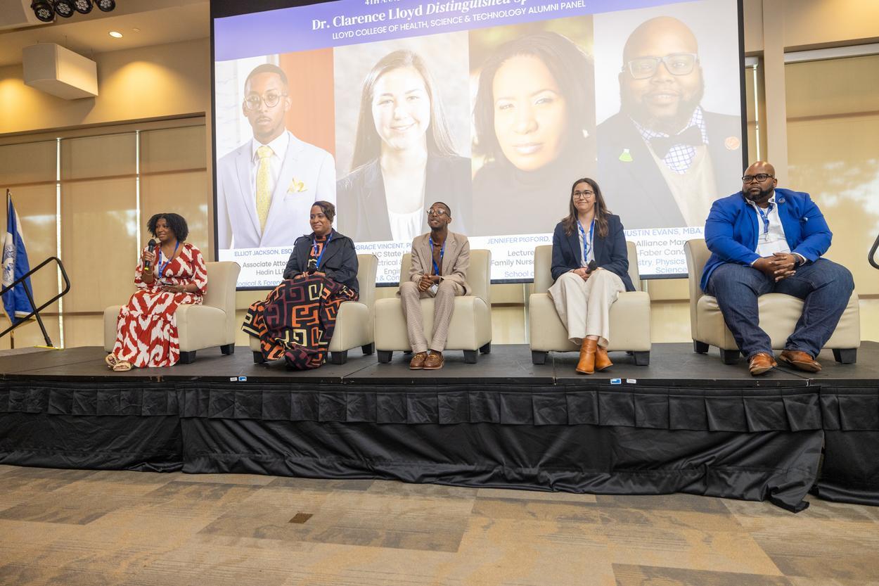 A panel of speakers on a stage.