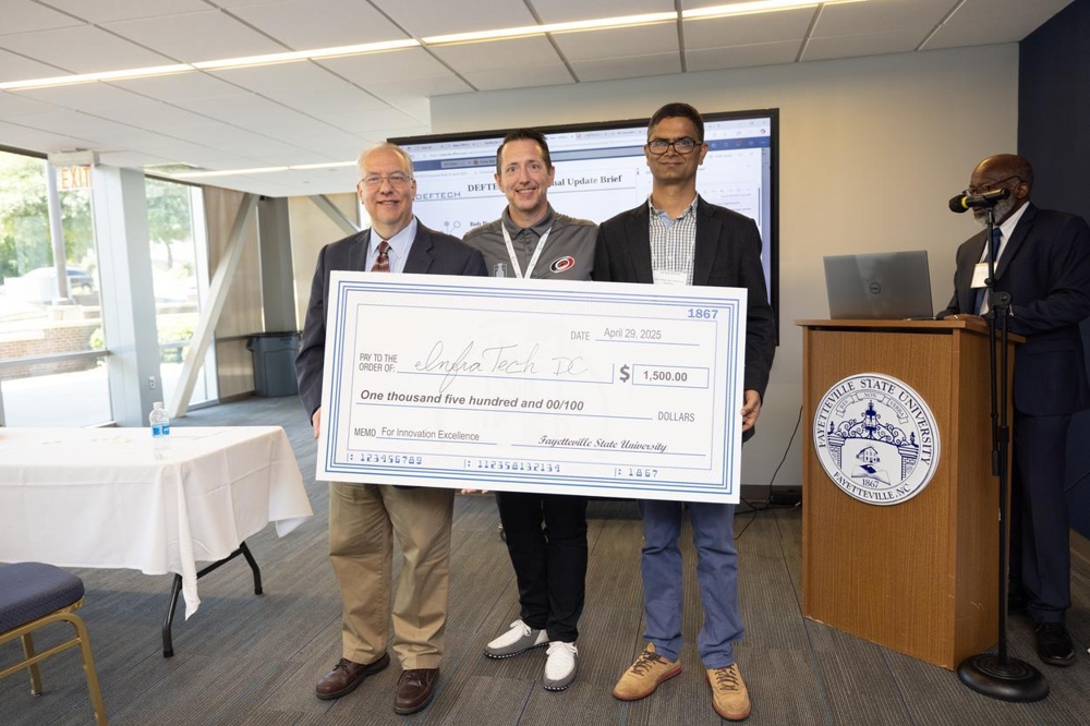 CEO of InfraTechDC with faculty members, presenting a giant check.