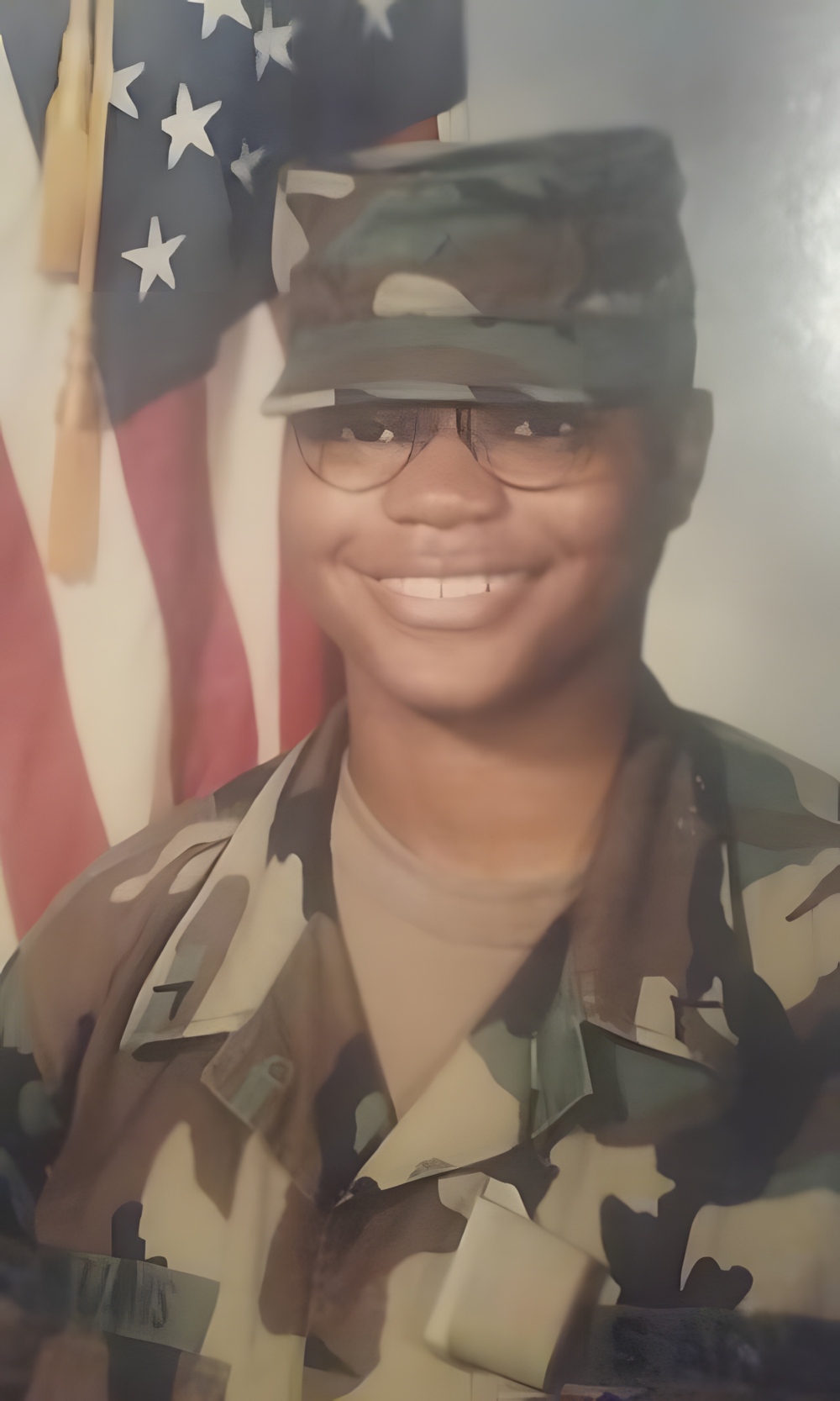 Mosley in uniform, standing in front of a flag.