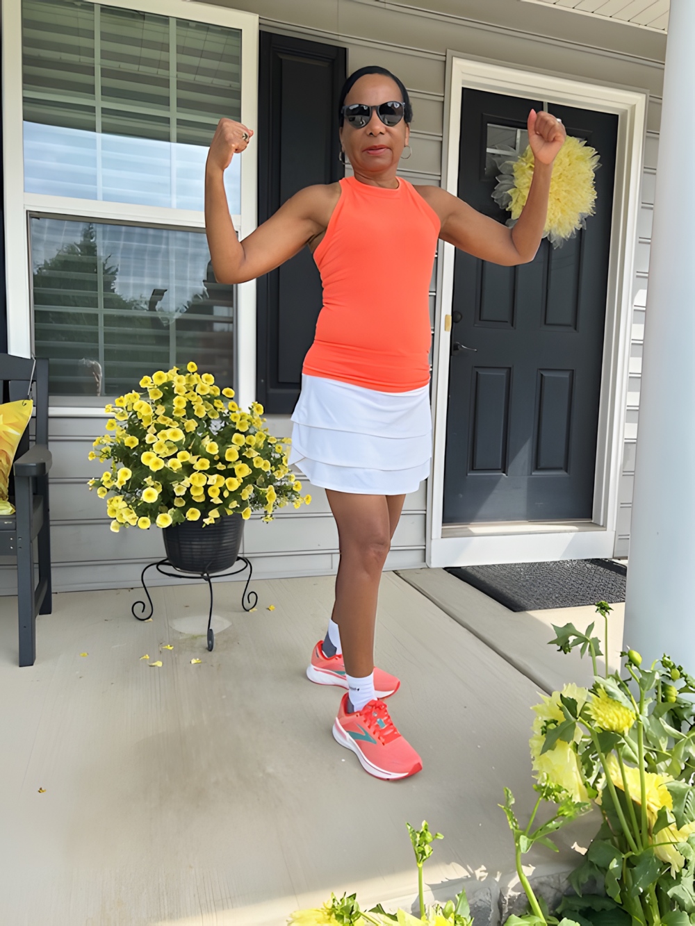 T J standing triumphantly her arms, raised.