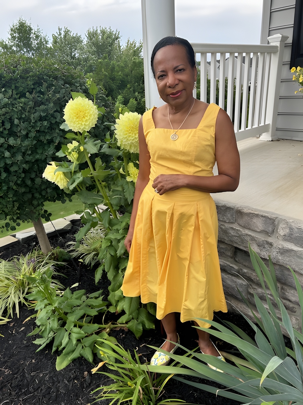 T J standing beside a sunglower.