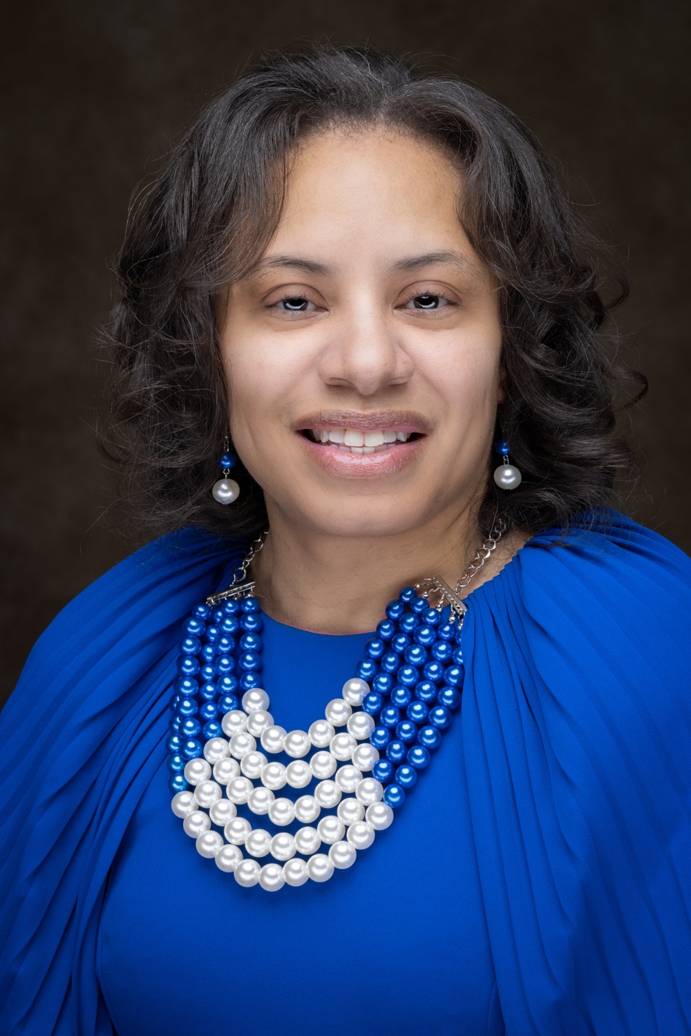 A smiling women in a blue dress.