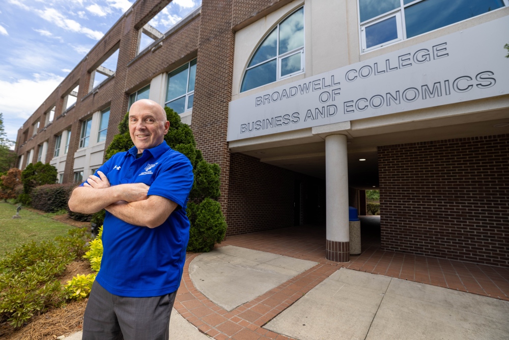 Dr. Robert W. McGee in a blue FSU polo shirt, with his arms crossed.