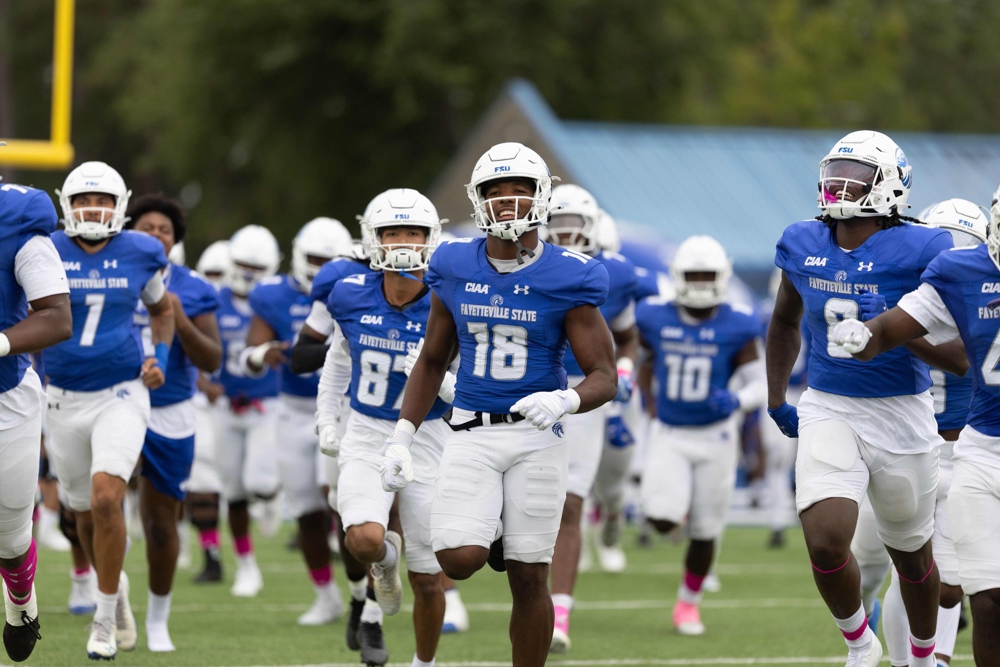 Football players in blue uniforms facing camera.