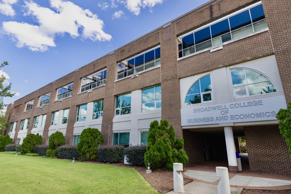 A photo of the exterior of a brick and concrete building standing proudly a sign reads: BROADWELL COLLEGE OF BUSINESS AND ECONOMICS