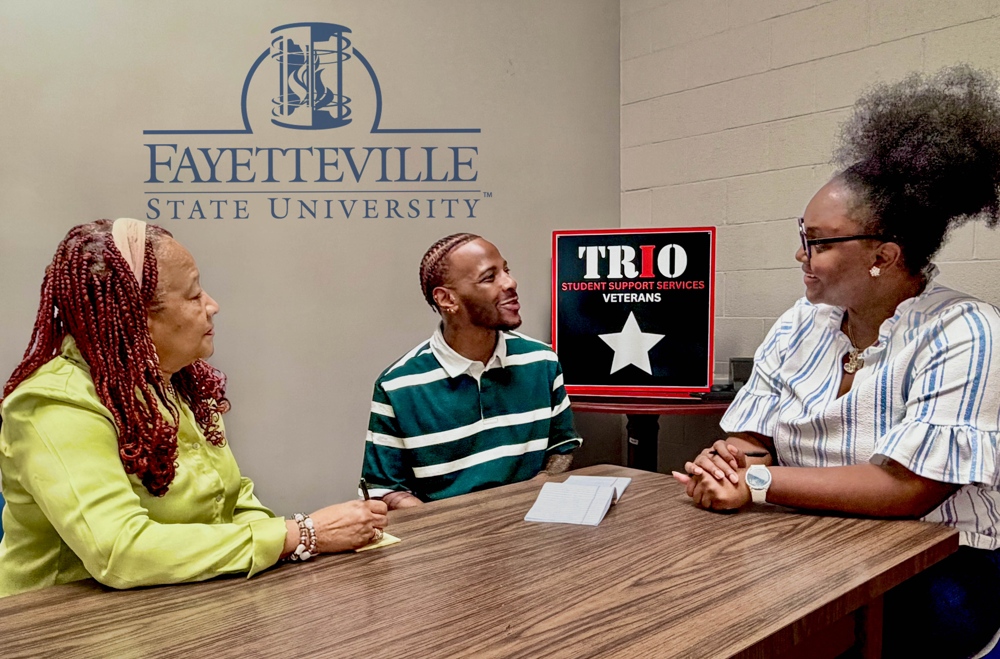A pair of FSU staff working with a student in the TRIO offices.