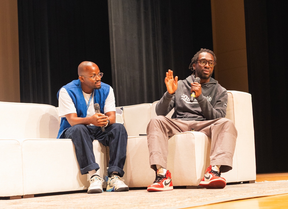 Two men holding mike's talking on stage.
