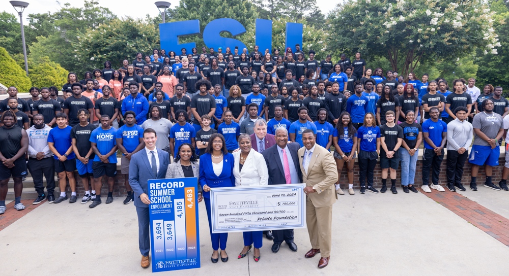 The Chancellor standing with a giant novelty check.