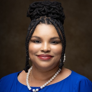 Headshot of Courtnee Barnett in a blue blouse with pearls.